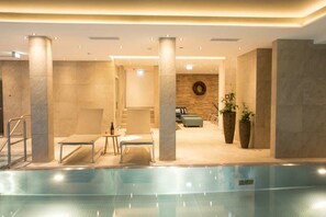 Una piscina cubierta, tumbonas