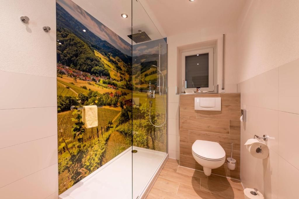 A modern bathroom with a glass shower enclosure, a toilet, and a sink.