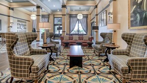 A spacious lounge with a patterned carpet, a central coffee table, and a sofa set. - Tapestry by Hilton The Peery Salt Lake City Downtown, UT (Salt Lake City)