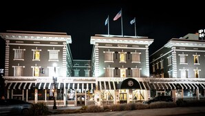 A hotel with a classic architectural style, featuring a central entrance with a canopy and multiple flags on top. - Tapestry by Hilton The Peery Salt Lake City Downtown, UT (Salt Lake City)