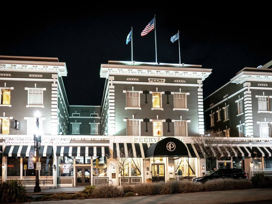 Un hotel de estilo arquitectónico clásico, con una entrada central con dosel y múltiples banderas en la parte superior.