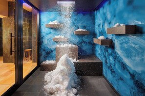 A modern interior with a blue wall and a central column of stacked blocks, some with snow-like material. - Hotel Erbprinz - Gourmet & Spa (Ettlingen)