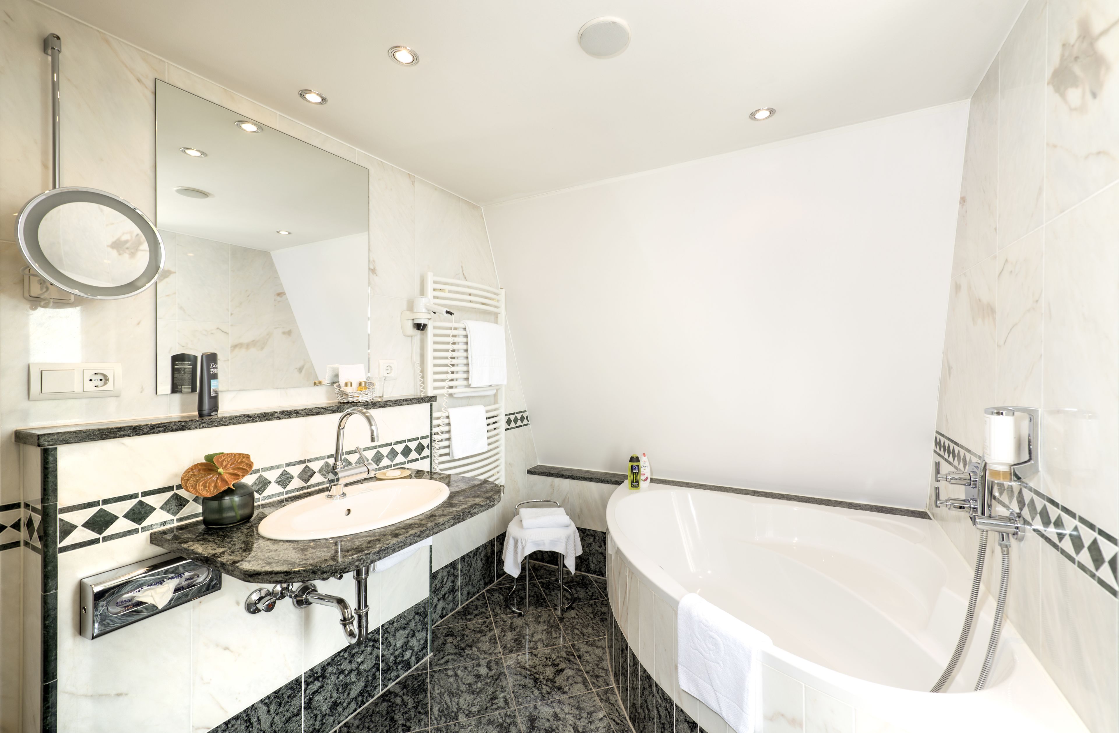 Une salle de bain moderne avec un grand miroir, un lavabo, une baignoire et une douche.