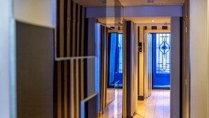 Un pasillo moderno con puertas de cristal que dan a una habitación.