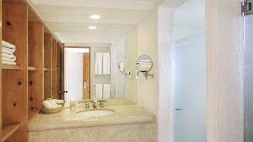 Un bagno con due lavandini, scaffali in legno e uno specchio.