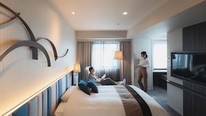 A hotel room with a large bed, a TV, a desk, and a window with curtains. - Hotel JAL City Miyazaki (Miyazaki)