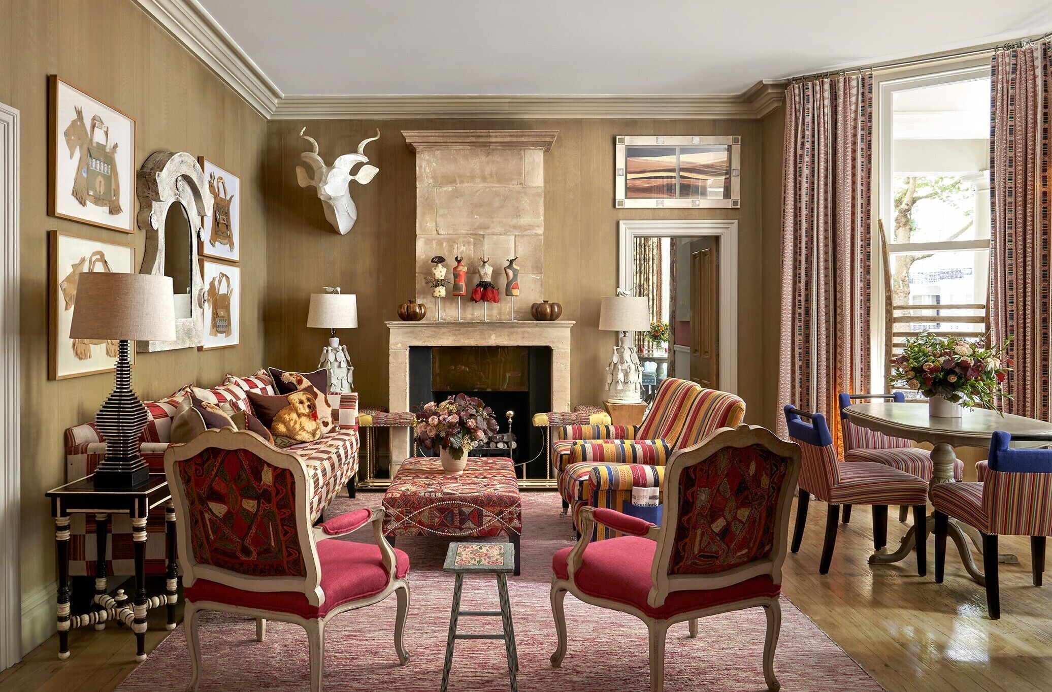 A traditional living room with a fireplace, patterned furniture, and artwork on the walls.
