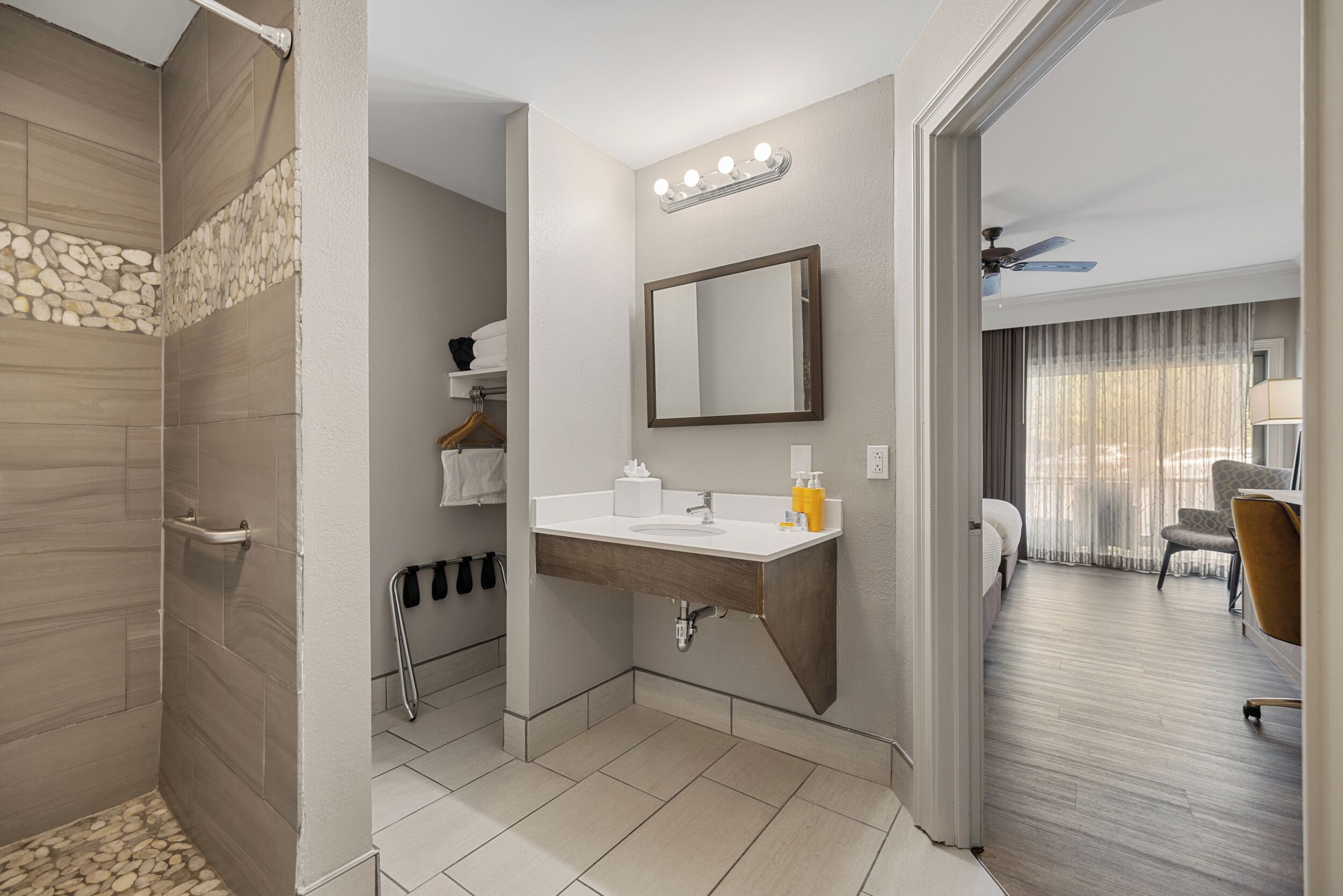 A modern bathroom with a shower, sink, and mirror.