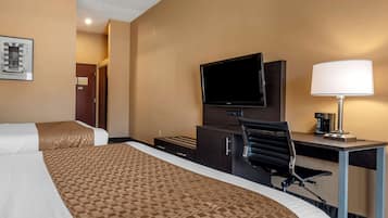 Habitación de hotel con dos camas, un escritorio, una silla, un televisor y una lámpara.