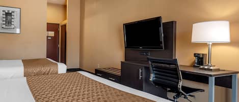 A hotel room with two beds, a desk, a chair, a television, and a lamp.