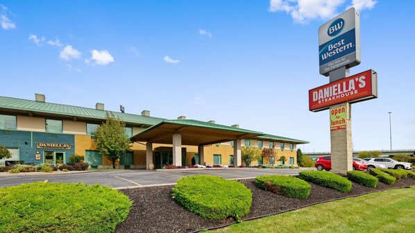 A hotel with a covered entrance, a sign for 'Best Western', and a 'Daniella's Steakhouse' sign. - Best Western The Inn At The Fairgrounds (Syracuse)