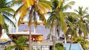 A hotel with a modern design, featuring a large glass facade and a rooftop area with a pool.