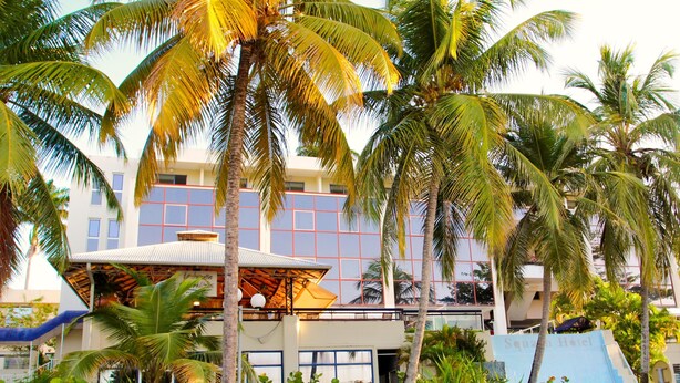 A hotel with a modern design, featuring a large glass facade and a rooftop area with a pool. - Karibea Squash Hôtel (Fort-de-France)