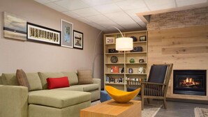 A living room with a green sofa, a wooden coffee table, a bookshelf, and a fireplace.
