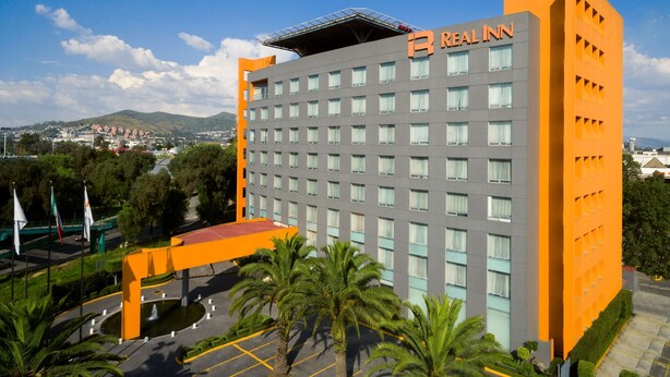A hotel with a modern design, featuring a prominent orange and grey color scheme.