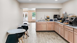 Une cuisine moderne avec des meubles en bois, un four encastré et un coin café.