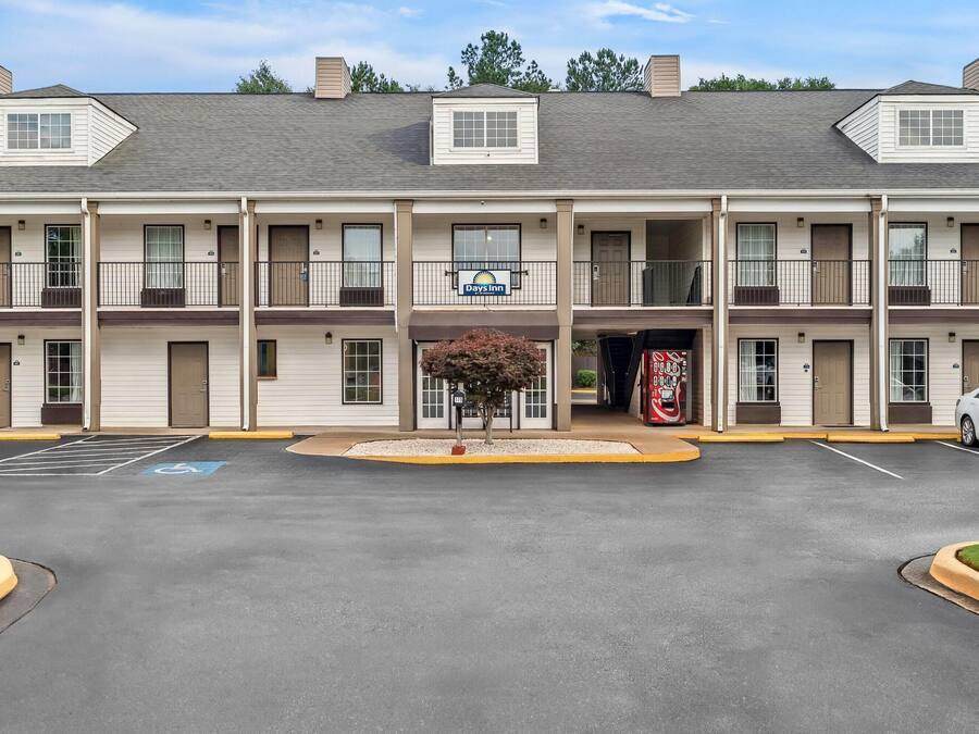 Un motel à plusieurs étages doté d’un parking, de places de stationnement accessibles aux personnes handicapées et d’une enseigne Days Inn.