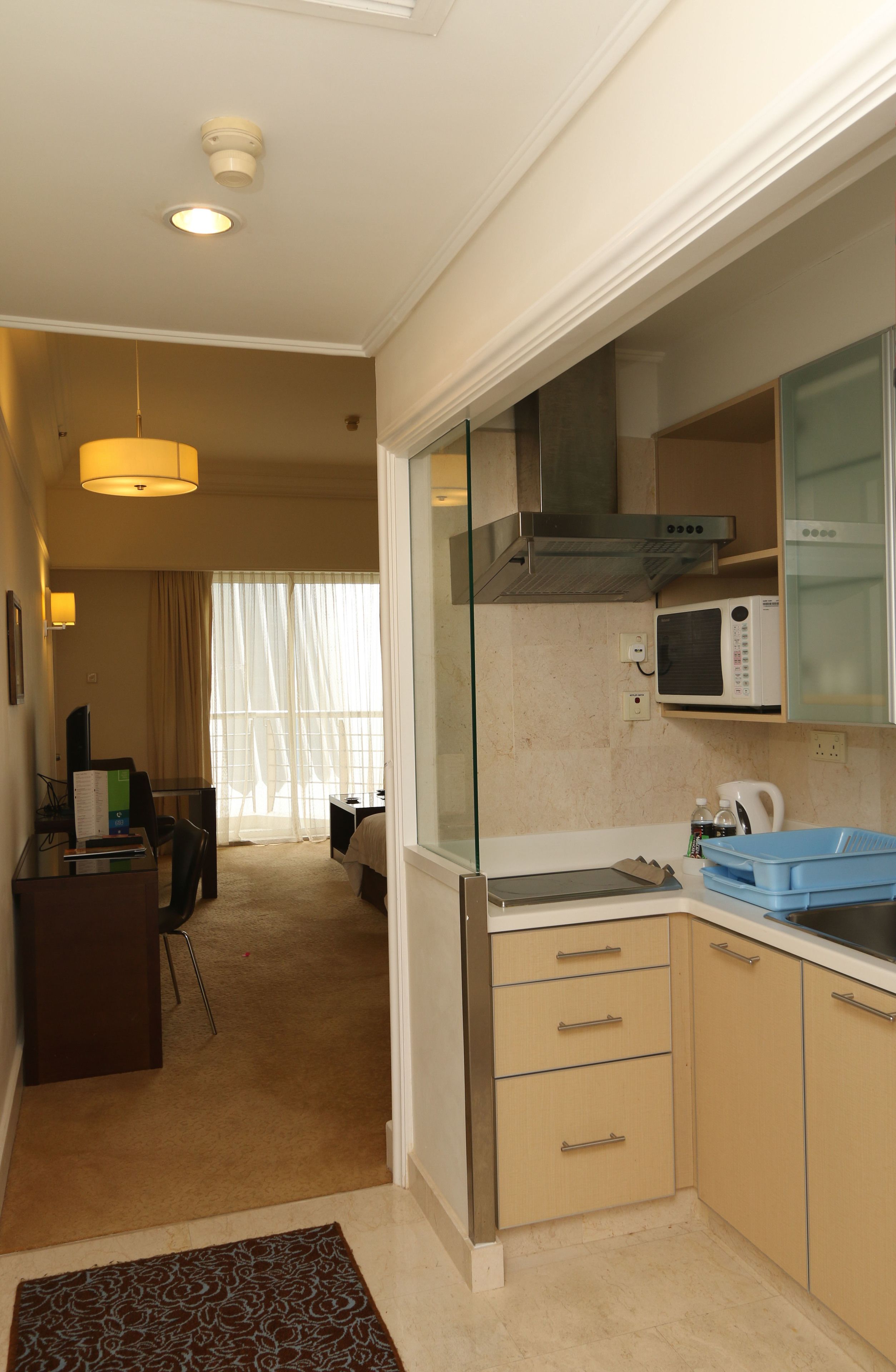 A compact hotel room with a kitchenette, a dining area, and a separate bedroom.