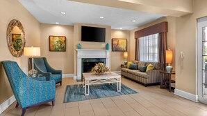 A living room with a fireplace, a television, and two sofas.