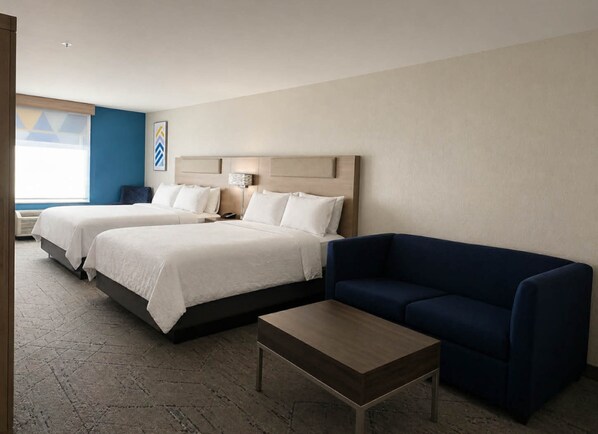 A hotel room with two beds, a blue sofa, a wooden coffee table, and a large window with a view. - Holiday Inn Express Hotel & Suites Murphy by IHG (Murphy)