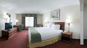 A hotel room with a bed, a television, a desk, a chair, and a painting on the wall. - Holiday Inn Express Hotel & Suites Murphy by IHG (Murphy)