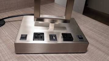 A metallic power strip with five sockets on a textured surface.