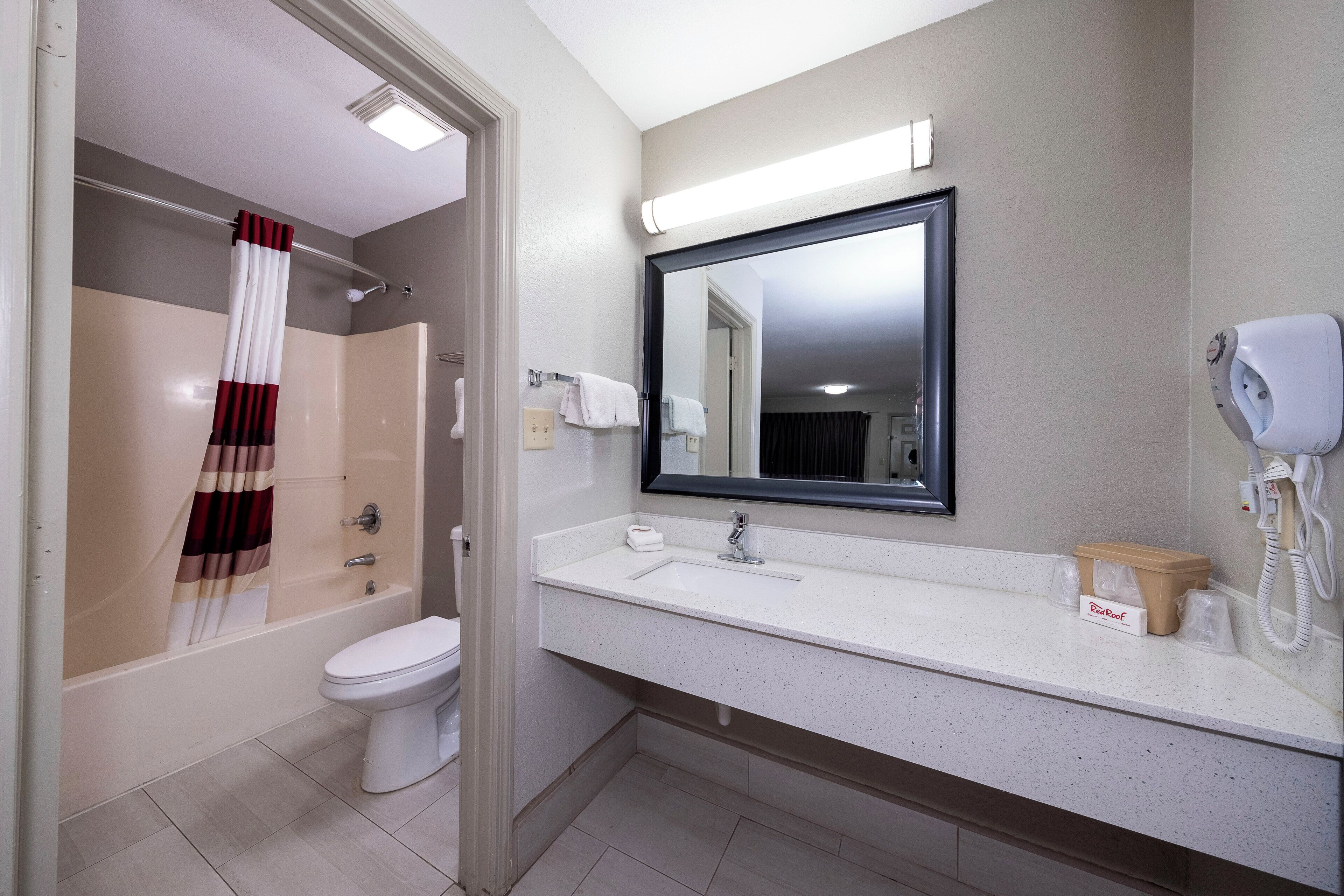 A bathroom with a shower, toilet, and sink.
