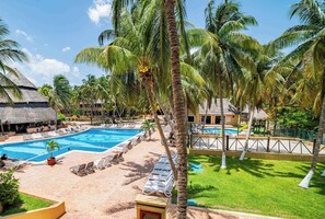Una piscina al aire libre, sombrillas, sillones reclinables de piscina