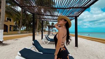 Playa privada, playa de arena blanca, camastros y sombrillas