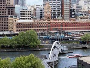 Une vue urbaine mettant en valeur un imposant bâtiment en briques rouges, un pont et une rivière.