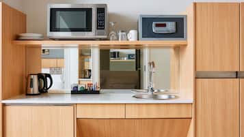 A compact kitchen with a microwave, a coffee maker, and a sink.