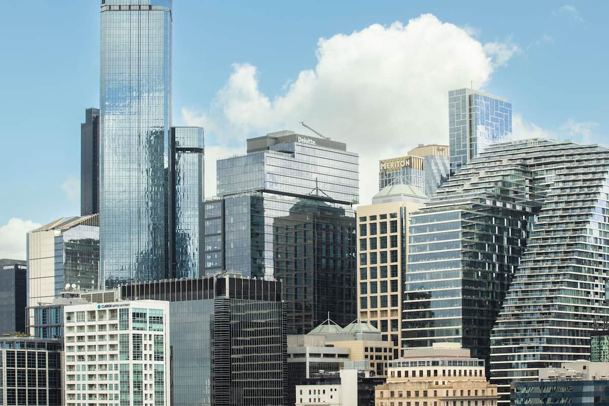 Un paysage urbain avec des immeubles modernes de grande hauteur, dont un bâtiment à la forme incurvée remarquable et plusieurs structures à façade vitrée.