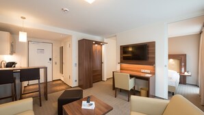 Une chambre d’hôtel équipée d’une kitchenette, d’un coin repas, d’une télévision et d’un lit.
