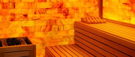 A sauna with wooden benches and a stone wall.