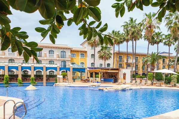 Relax by the pool surrounded by lush greenery and Mediterranean-inspired architecture.