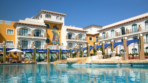 A hotel with a swimming pool, multiple balconies, and a clear blue sky. - Hotel La Laguna Spa And Golf (Rojales)