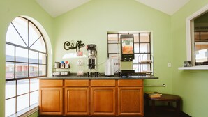 Una cocina con armarios de madera, una cafetera y un ventanal con vistas.