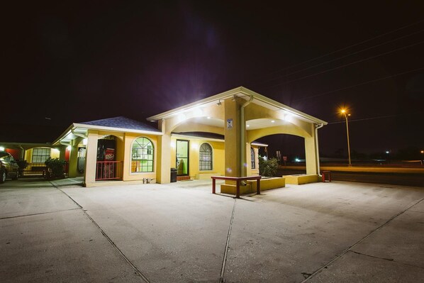 A building with a covered entrance and a small outdoor seating area.