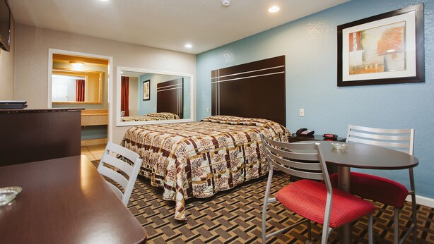Una habitación de hotel con cama, escritorio, silla y mesa.