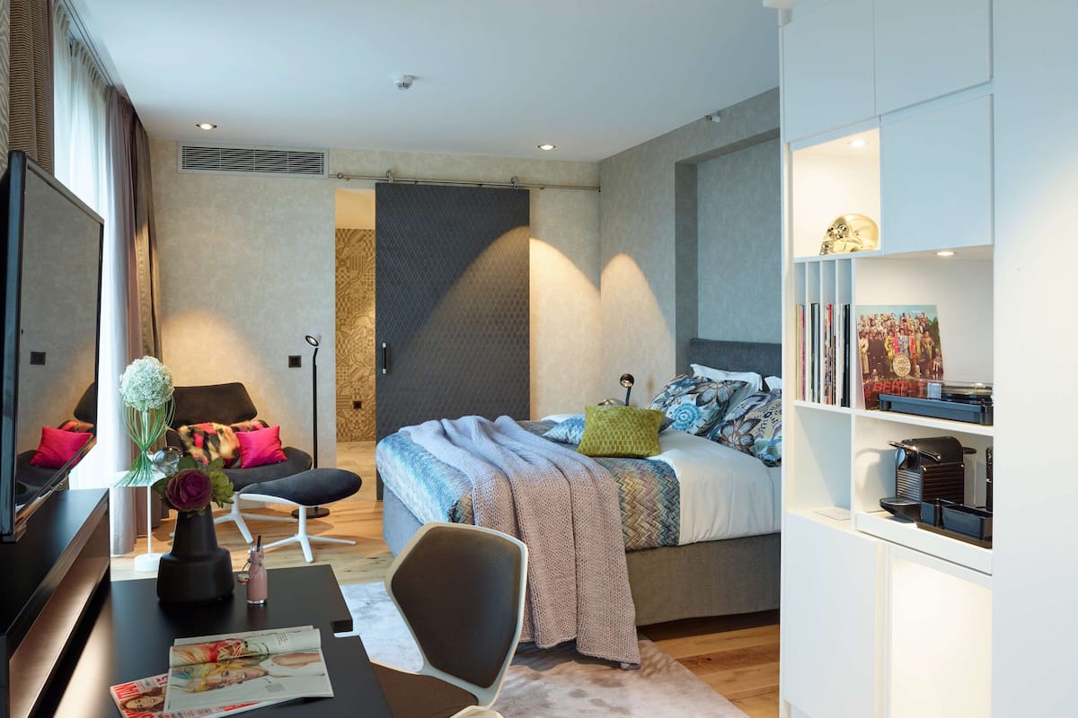 Ein modernes Schlafzimmer mit einem Bett, einem Schreibtisch und einem Bücherregal.