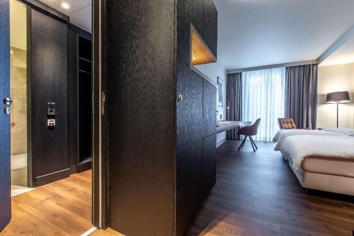 Ein Hotelzimmer mit einem Bett, einem Schreibtisch, einem Stuhl und einem Kleiderschrank.