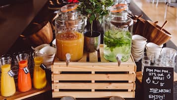 A beverage station with various drinks and a sign indicating apple juice and wild water.