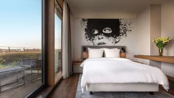 Ein modernes Schlafzimmer mit einem großen Bett, Blick ins Freie und einem einzigartigen Kunstwerk an der Wand.