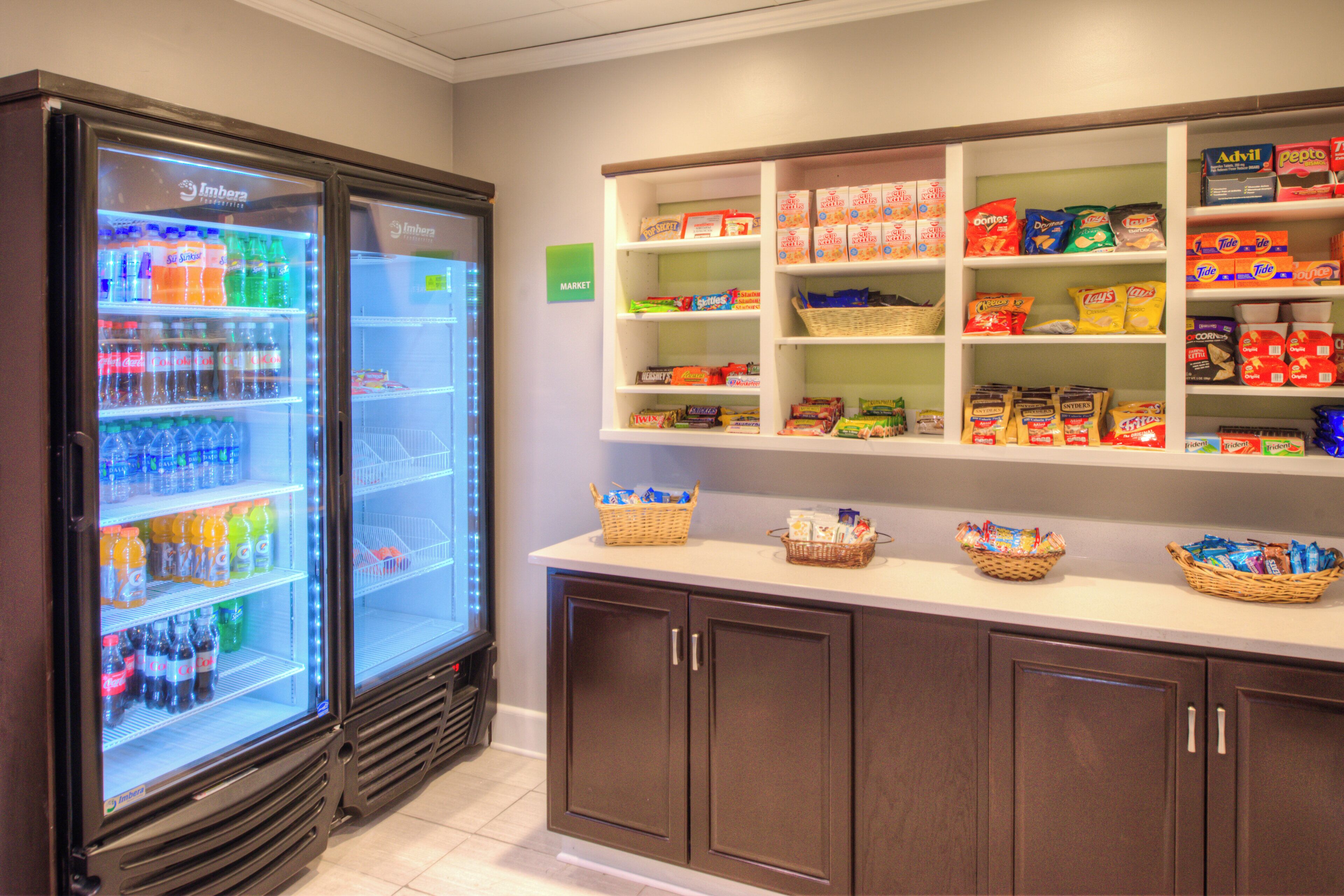 A refrigerated beverage display and snack shelves in a store.