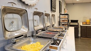 Una mesa de buffet con varios dispensadores de comida para servirse.