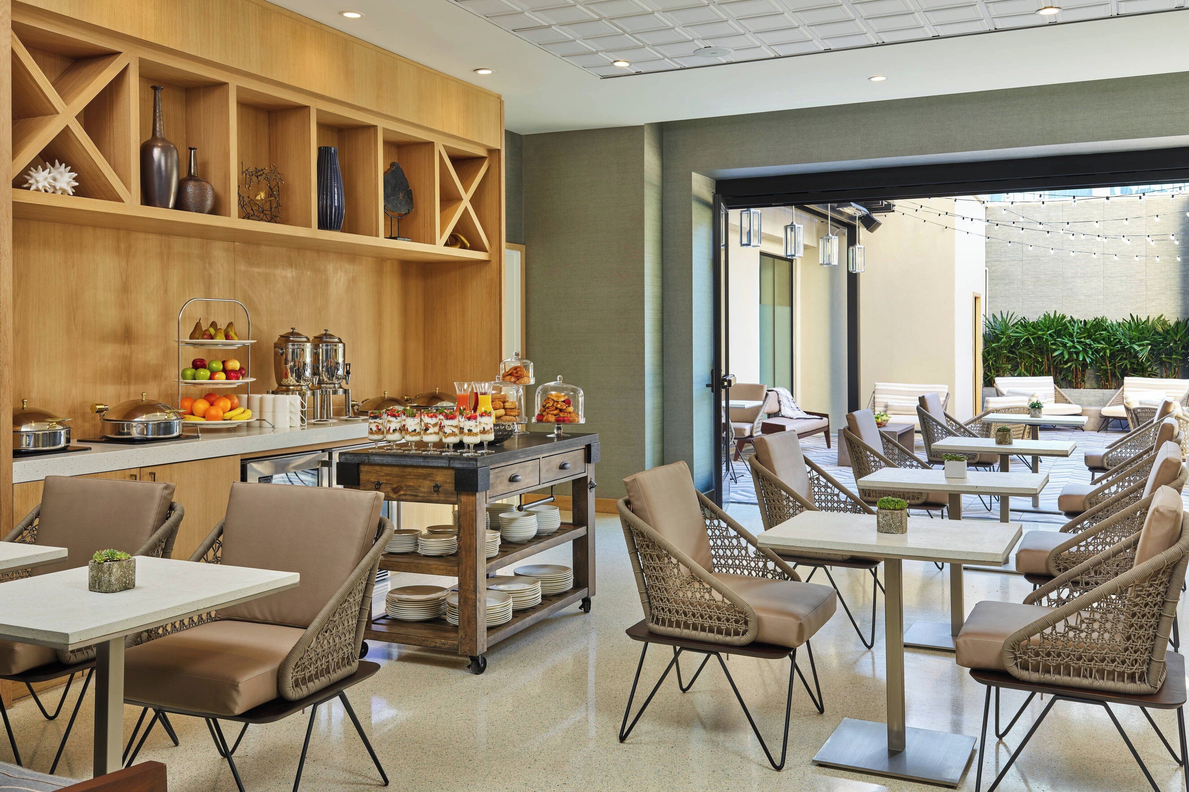 Un ristorante con scaffali in legno, sedie in vimini e un'area buffet.
