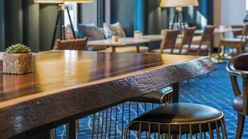 A hotel dining area with wooden tables, chairs, and lamps.