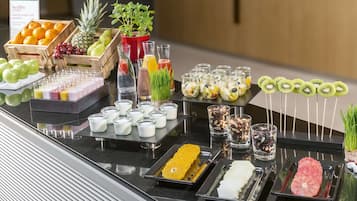 A buffet with fruits, juices, and various food items.