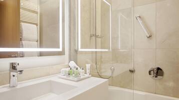 A modern bathroom with a large mirror, two sinks, a bathtub, and a glass-enclosed shower.