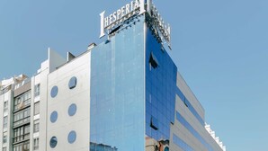A modern hotel with a reflective glass facade and a prominent sign at the top. - Hesperia A Coruña Centro (A Coruña)